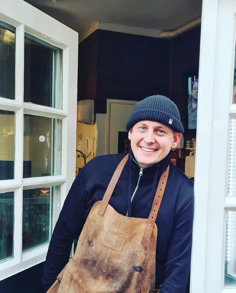 Portrait of Nick in front of the Holyburgers door
